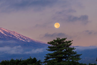 Scenic view of mountains against sky during moon set
