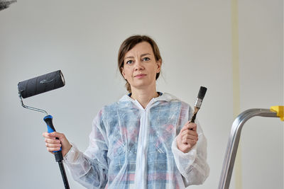 Portrait of smiling young woman standing against white background
