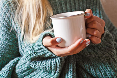 Midsection of woman holding coffee