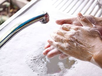 Close-up of person hand with reflection in water