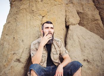 Young man sitting on rock