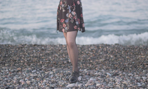 Low section of woman standing on beach