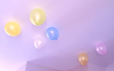 Low angle view of colorful helium balloons on ceiling