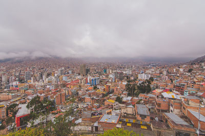 Aerial view of cityscape against cloudy sky