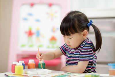 Cute girl learning painting at school