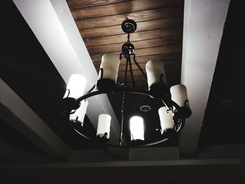 Low angle view of illuminated pendant light hanging on ceiling at home