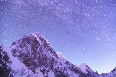 Scenic view of snowcapped mountain against star trail