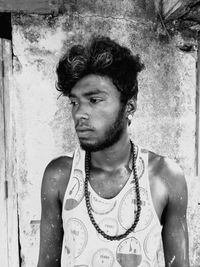 Portrait of young man standing against wall