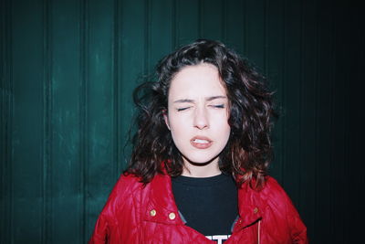 Portrait of beautiful woman standing against wall