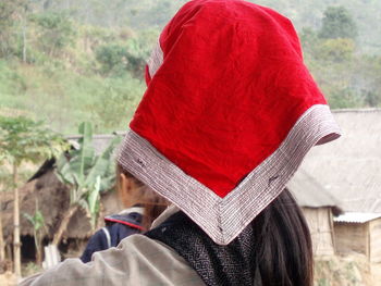 Girl with red head scarf seen from the back