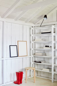 Red rain boots in white cabin with shelving