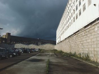 Road in city against cloudy sky