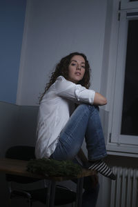 Young woman sitting on seat at home