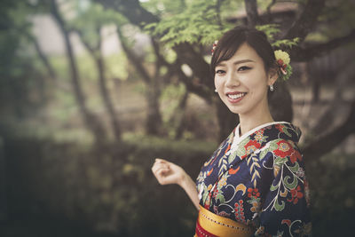 Portrait of smiling young woman standing outdoors