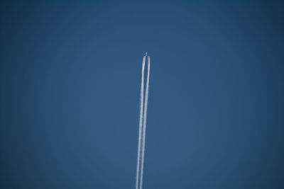 Low angle view of vapor trail against blue sky