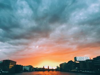 Oberbaumbruecke over spree river in city against cloudy sky