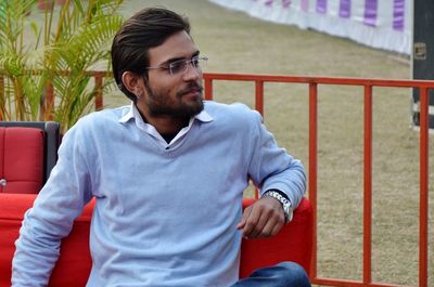 Young man sitting on bench in park