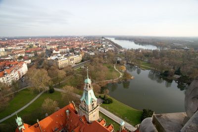 High angle view of new town hall by pond against cityscape