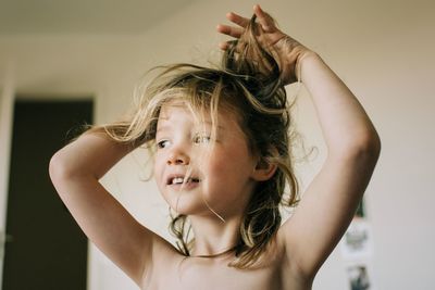 Candid portrait of young girl with bed head messy hair after waking up