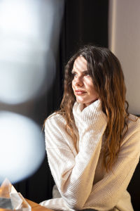 Woman sitting at home during sunny day