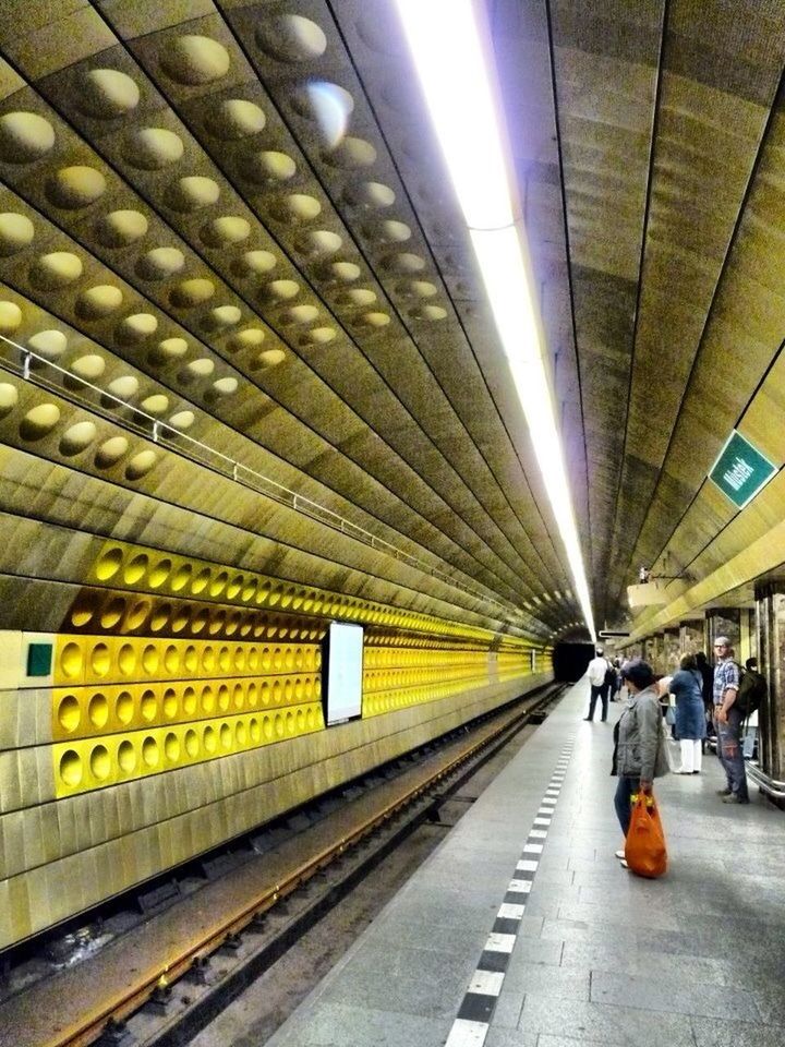 railroad station, railroad track, railroad station platform, public transportation, indoors, rail transportation, illuminated, transportation, subway station, ceiling, built structure, subway, architecture, the way forward, incidental people, diminishing perspective, travel, transportation building - type of building, lighting equipment, subway platform