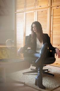 Woman sitting on window at home