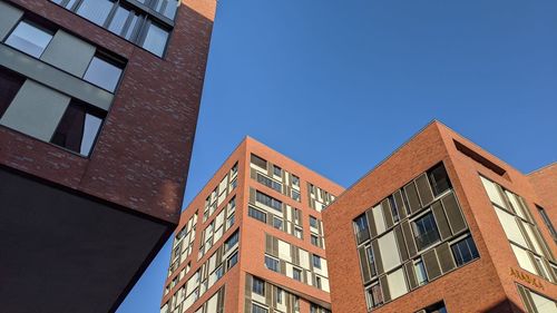 Low angle view of modern building against clear blue sky