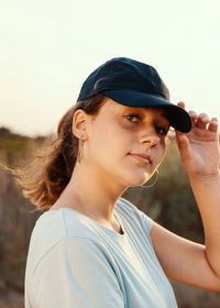 Young woman looking away against sky