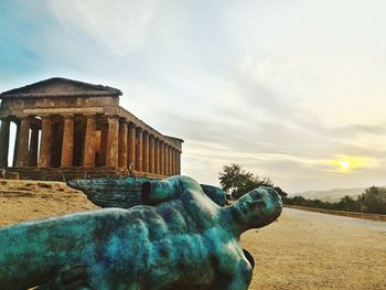 Statue of historic building against cloudy sky