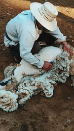 High angle view of man sitting on hat