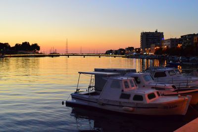 Boats moored in sea at dusk