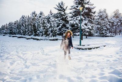 Woman with dog on snow covered field