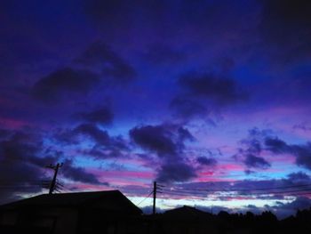 Low angle view of silhouette buildings against dramatic sky