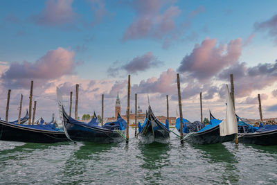 Traditional gondola moored by the famous rialto bridge in venice, italy.