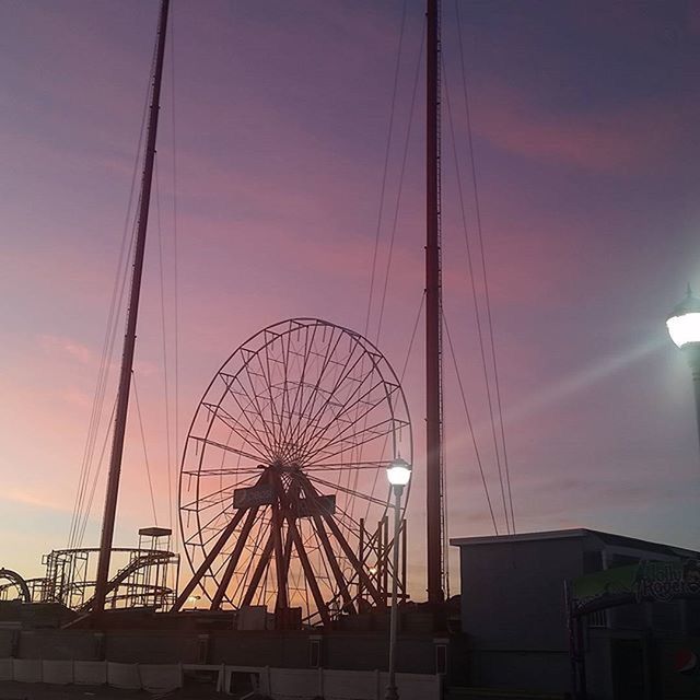 low angle view, sky, built structure, architecture, amusement park, ferris wheel, amusement park ride, arts culture and entertainment, cloud - sky, silhouette, sunset, outdoors, cloud, no people, cloudy, connection, orange color, building exterior, dusk, travel destinations