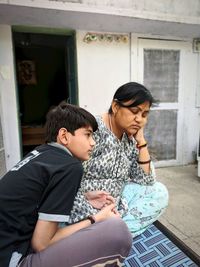 Rear view of couple sitting at home