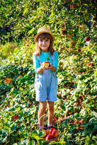 Portrait of girl standing amidst plants