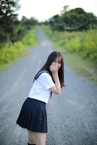 Portrait of woman standing on road