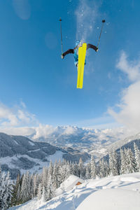 Low angle view of kite flying over snowcapped mountains against sky