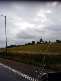 Road amidst field against sky