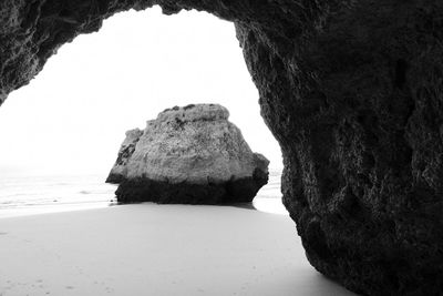 Rock formations on beach against clear sky