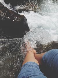 Low section of woman splashing water