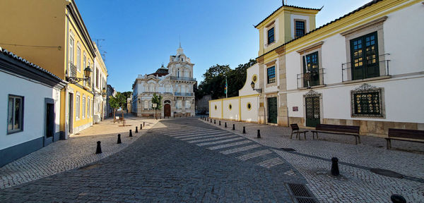 Street amidst buildings in town against sky