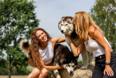 Smiling women with dogs outdoors