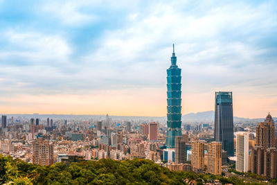 Modern buildings in city against cloudy sky