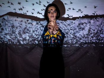 Portrait of woman standing against wall
