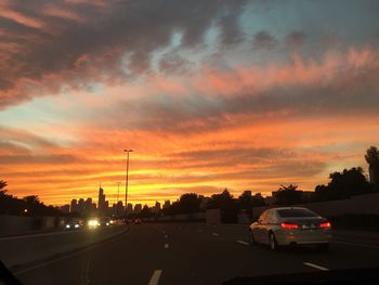 Cars on road at sunset