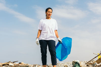 Latin woman with a bag over garbage