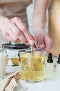 Midsection of man preparing food in glass on table