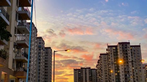 Low angle view of illuminated buildings against sky during sunset